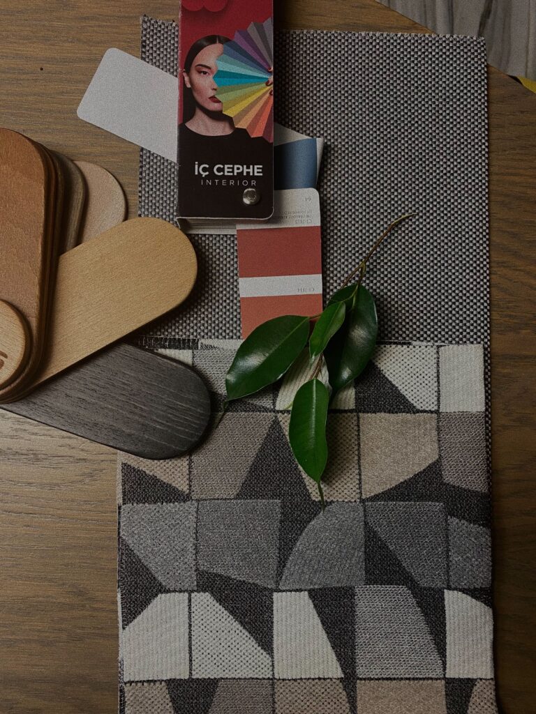 Flat lay of interior design samples featuring fabrics, color swatches, and wood textures.